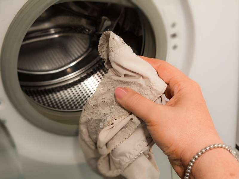 Colocando calcinha na máquina de lavar roupas.