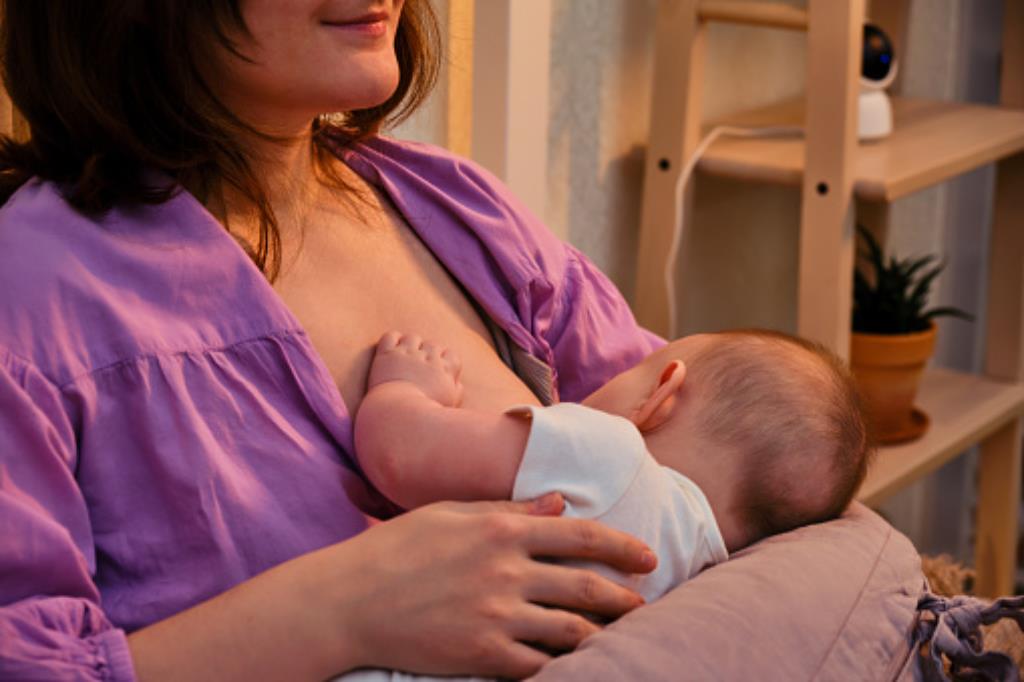 mulher amamentando o bebê usando a almofada de amamentação