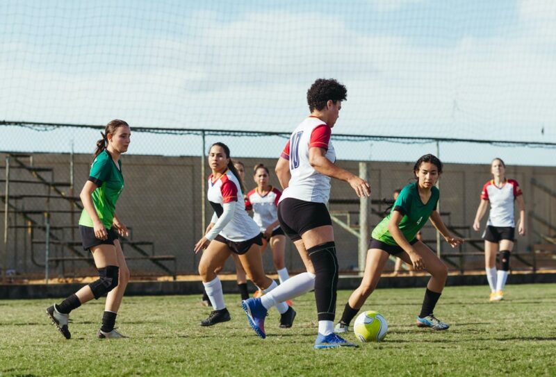 Time de mulheres jogando futebol como uma das Conquistas Femininas