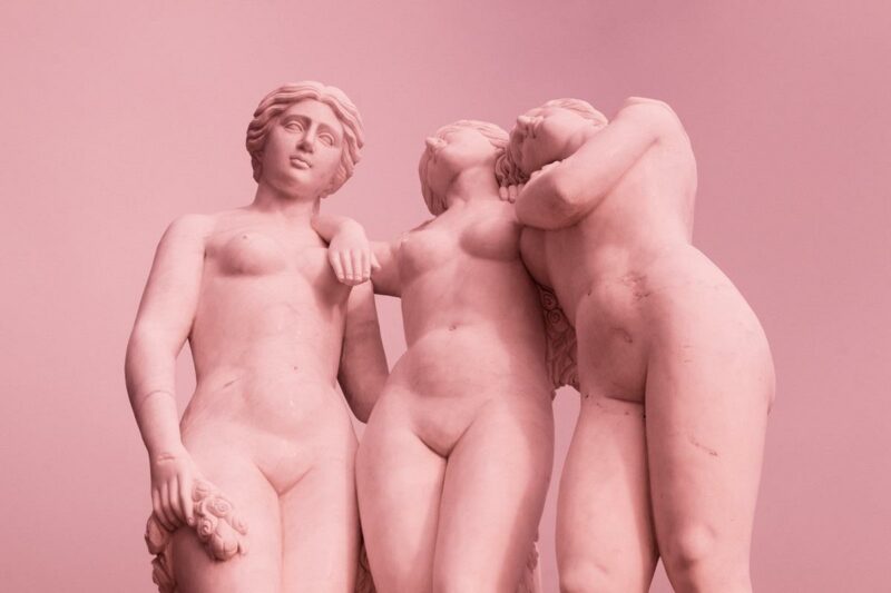 Imagem de quatro estátuas em um fundo rosa