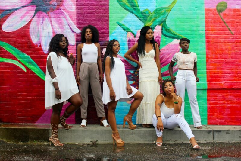 Mulheres negras posando para foto com as Conquistas Femininas